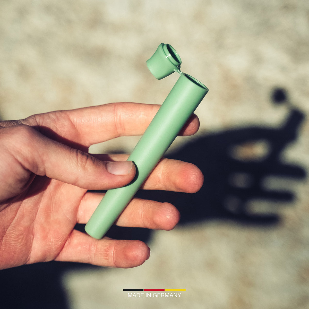 Geöffnete grüne SMOWE GREENTUBE Joint Tube in der Hand für die praktische und geruchsdichte Aufbewahrung von Joints unterwegs.