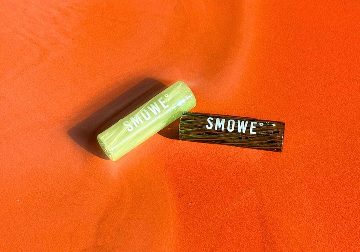 Zwei SMOWE Glas-Tips in Hellgrün und Dunkelgrün als wiederverwendbare Glasfilter für Cannabis-Joints.